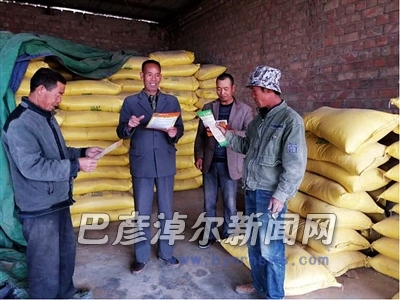 王安义（左二）向村民讲授收购知识（资料图）